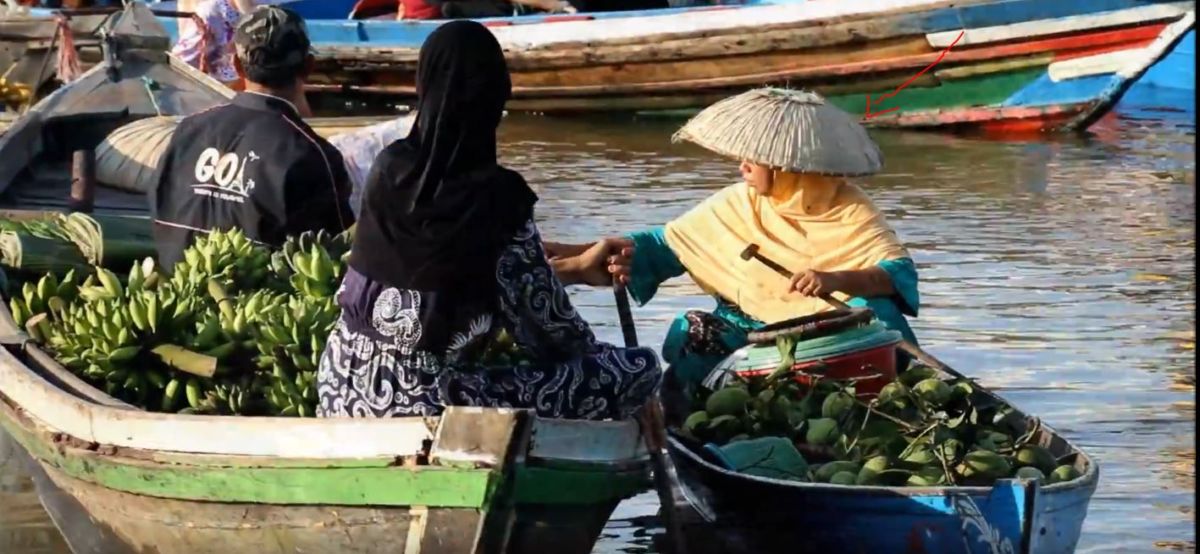 A lady with a traditional hat in Borneo Floating market in Indonesia